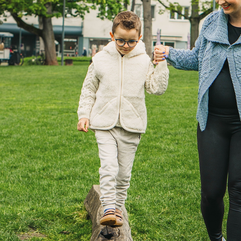 Kindervest van schapenwol met kap natuurlijk